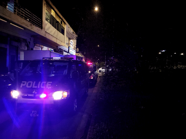 photo of a police van outside a massage establishment with blinkers on in a gif animation