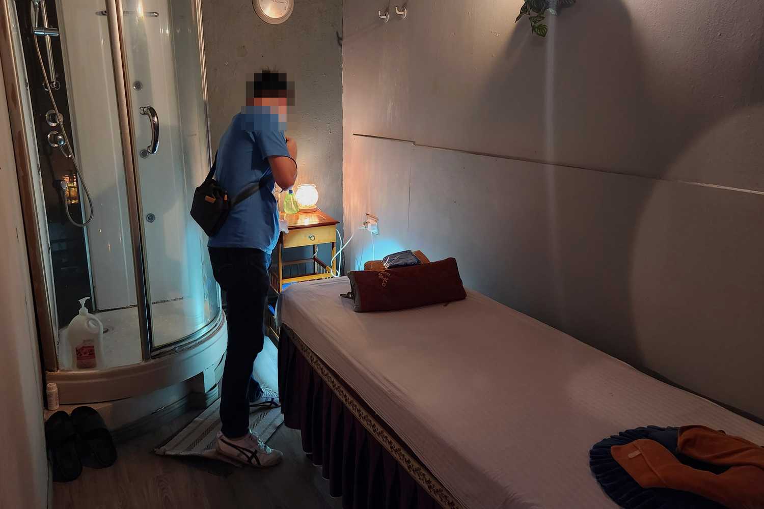 a police officer using his torchlight to check around the massage beds 
