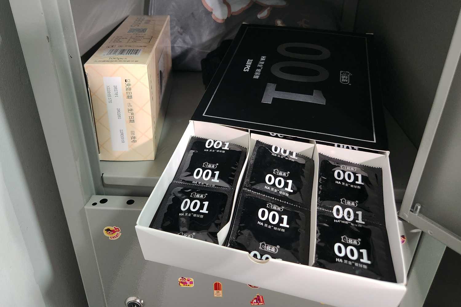 a photo of inside a staff's locker showing a box of condoms that are black and white covered with "001" brand printed on it