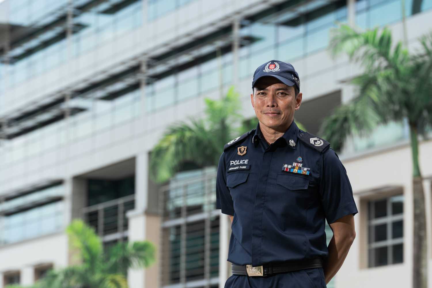 Station Inspector Farik, has no spectacles, wearing police uniform, well built, posing for a photo inside Home Team Academy