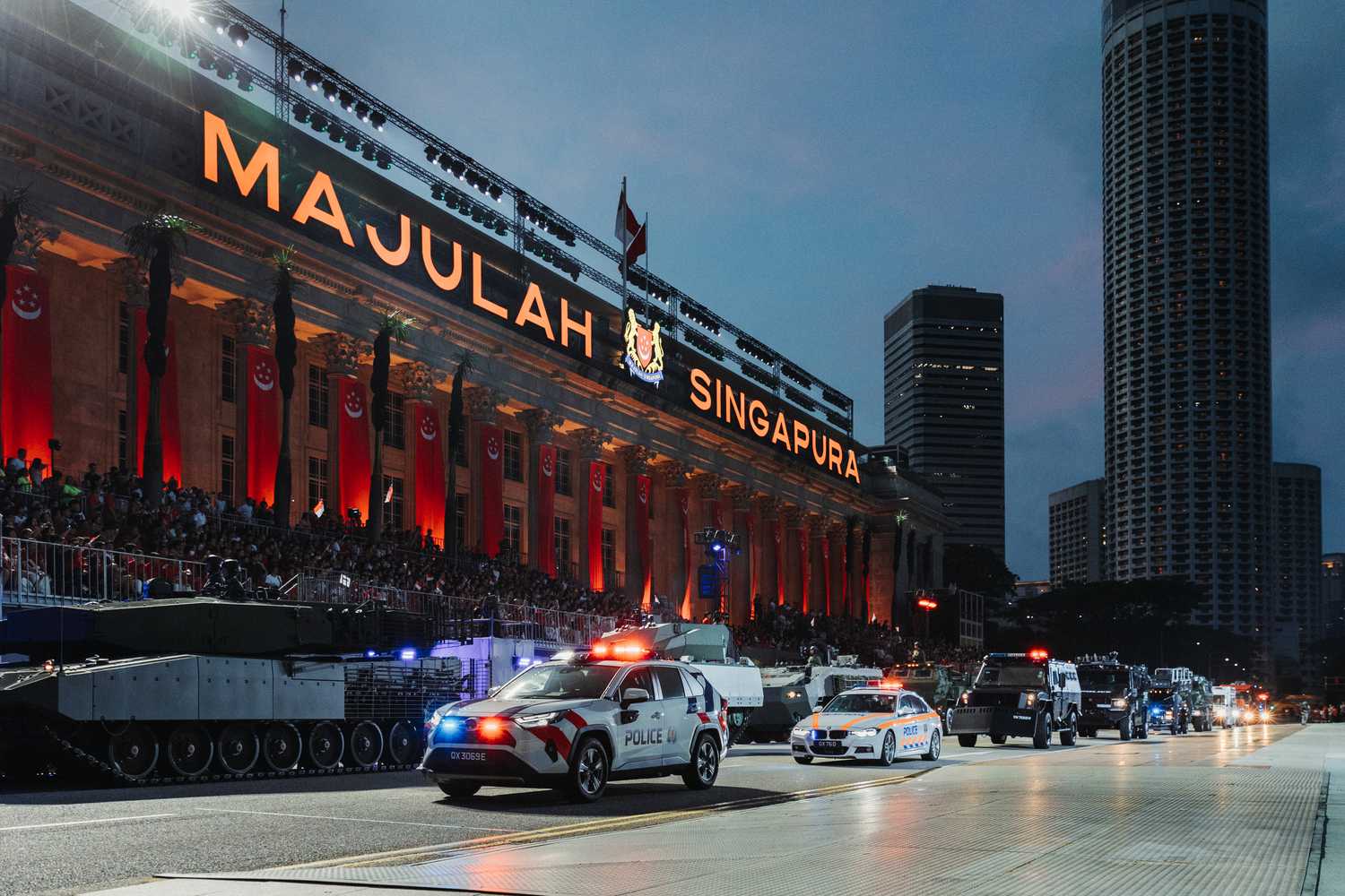 The lighted up words Majulah Singapura are on the National Gallery Building. The SPF's next-generation fast response car, Traffic Police Expressway Patrol Car, a riot vehicle called the Armored Personnel Carrier, and the SPF's latest edition to the Special Operations Command arsenal, the Tactical Strike Vehicle are doing a drive-by.