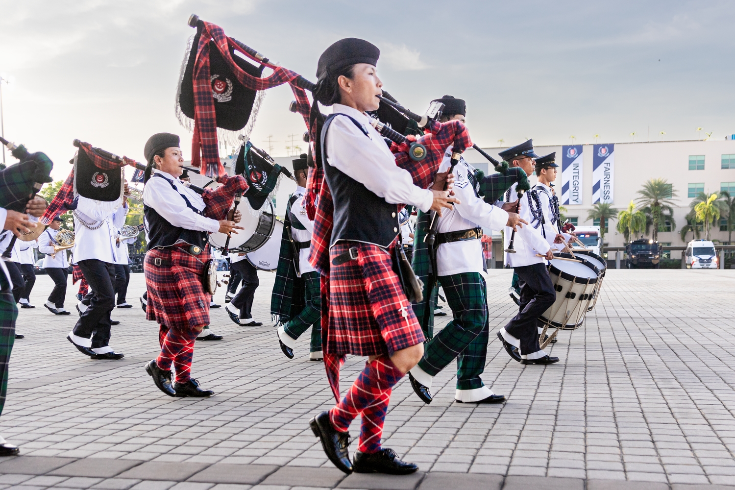 A wide shot of the WPPD performing with the SPF Band at the Police Day Parade on 3 June 2023. SI Julizah is pictured marching in the background while playing the bagpipe.