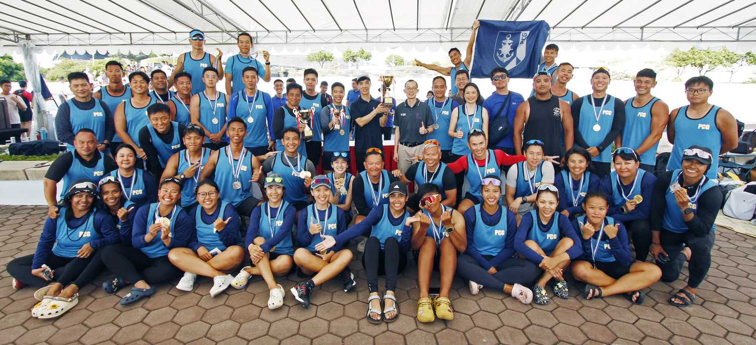 a team photo of three rows of people in blue singlets and medals around their necks