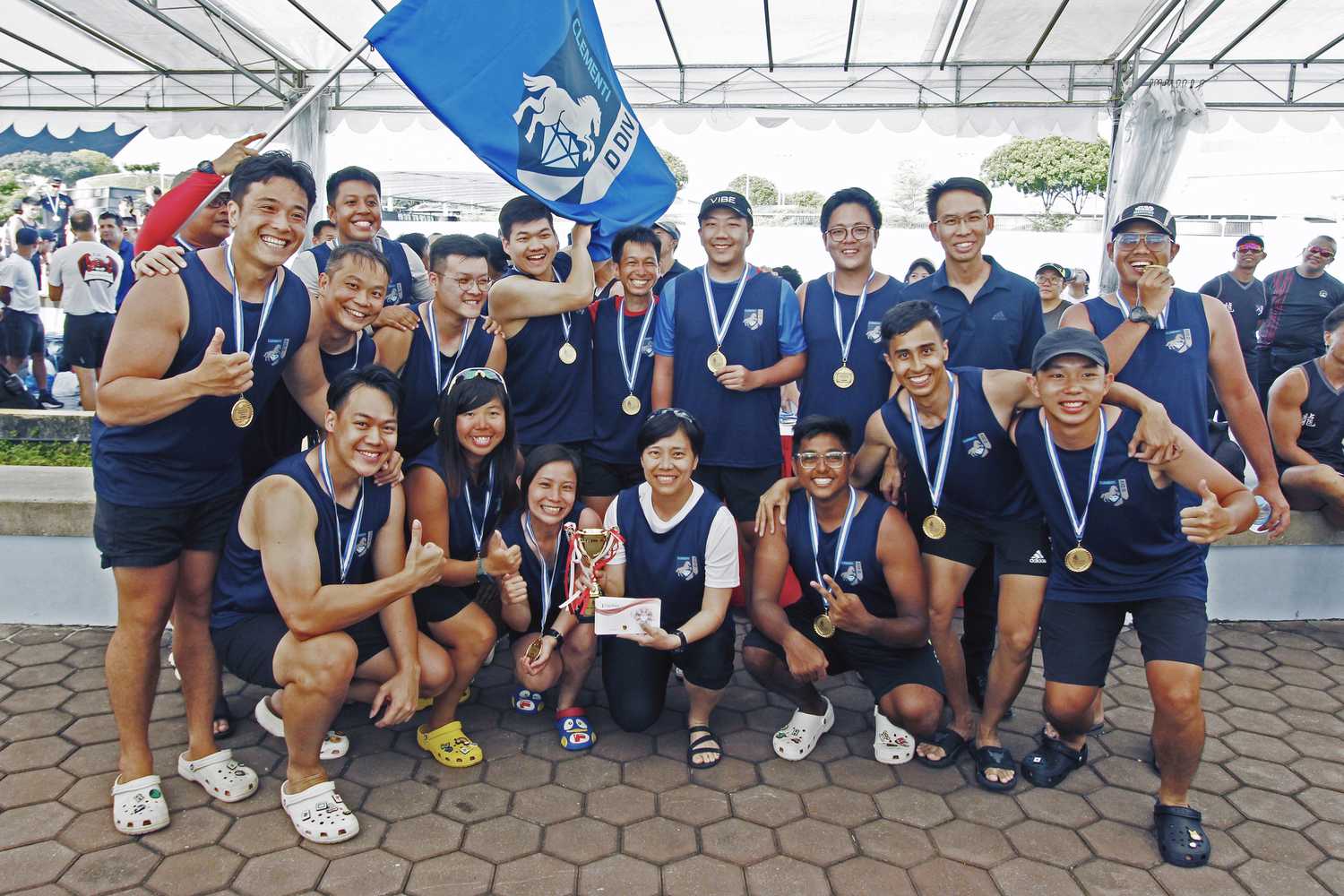 a team photo of two rows of people in black singlets and medals around their necks