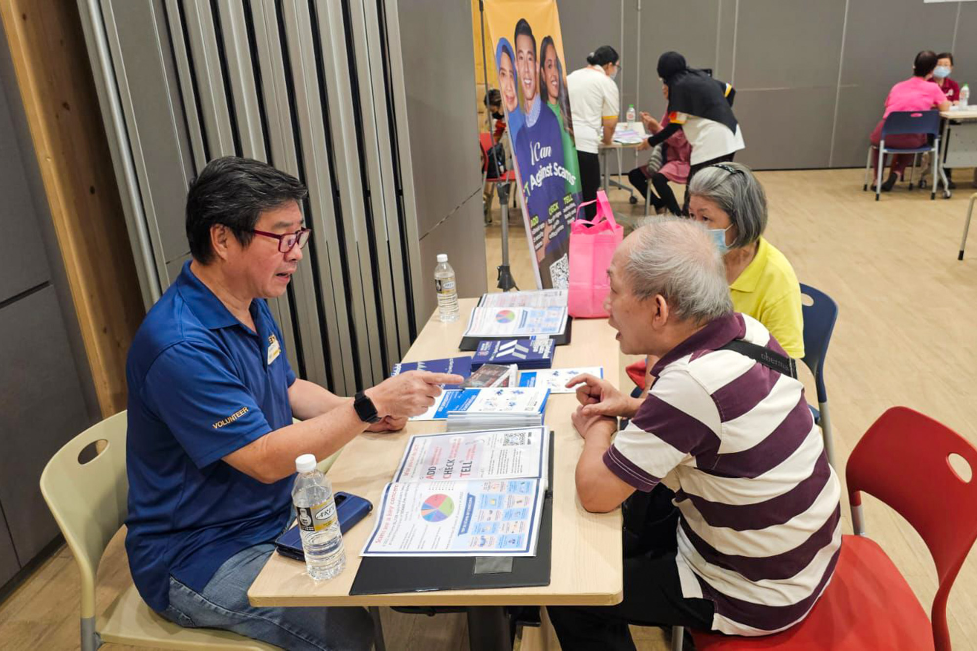 Mr Ong engaging with the seniors at an anti-scam booth set up at the Rivervale Community Centre in collaboration with the Silver Generation Office. PHOTO: Seng Kang NPC