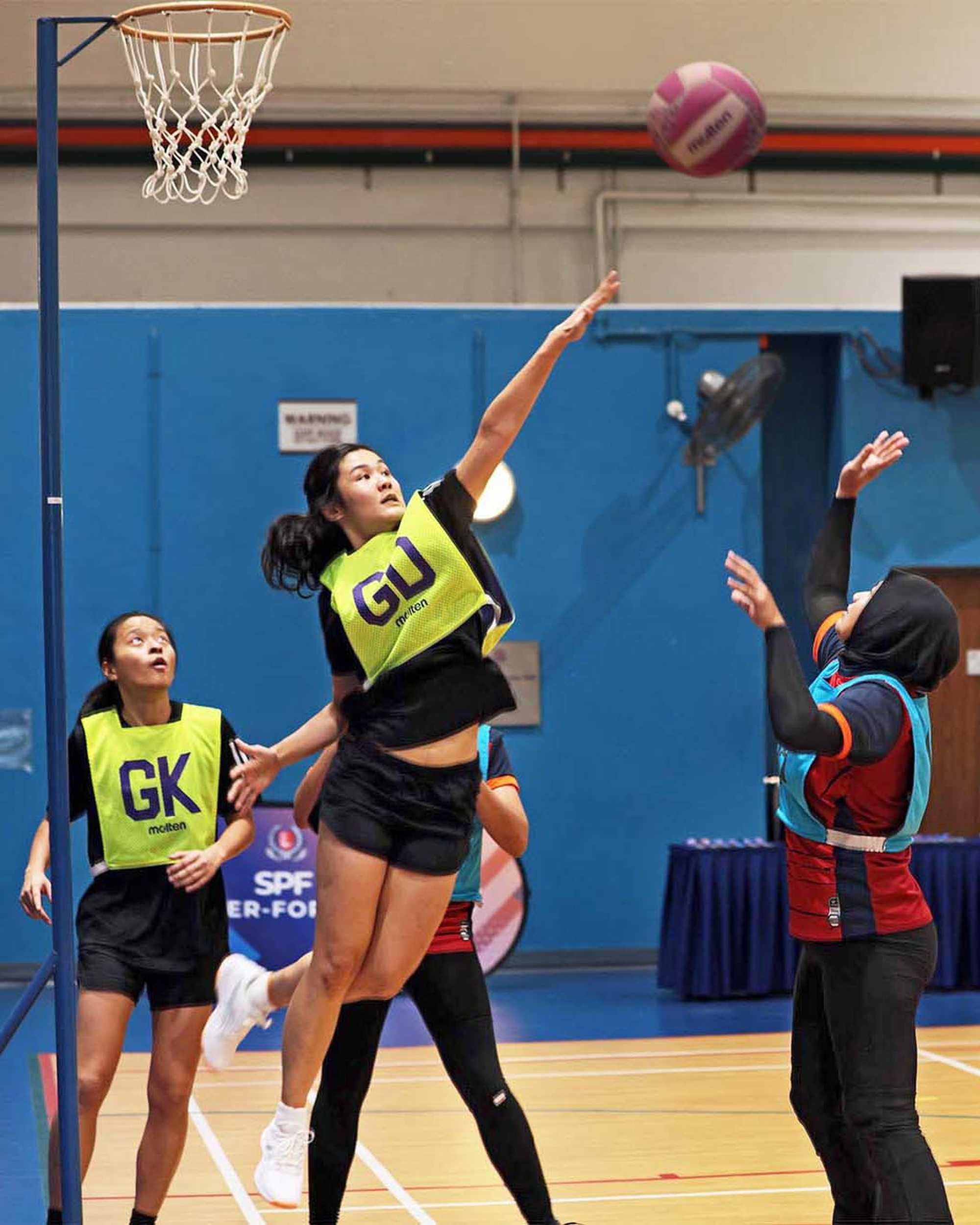 participants playing netball and jumping to score