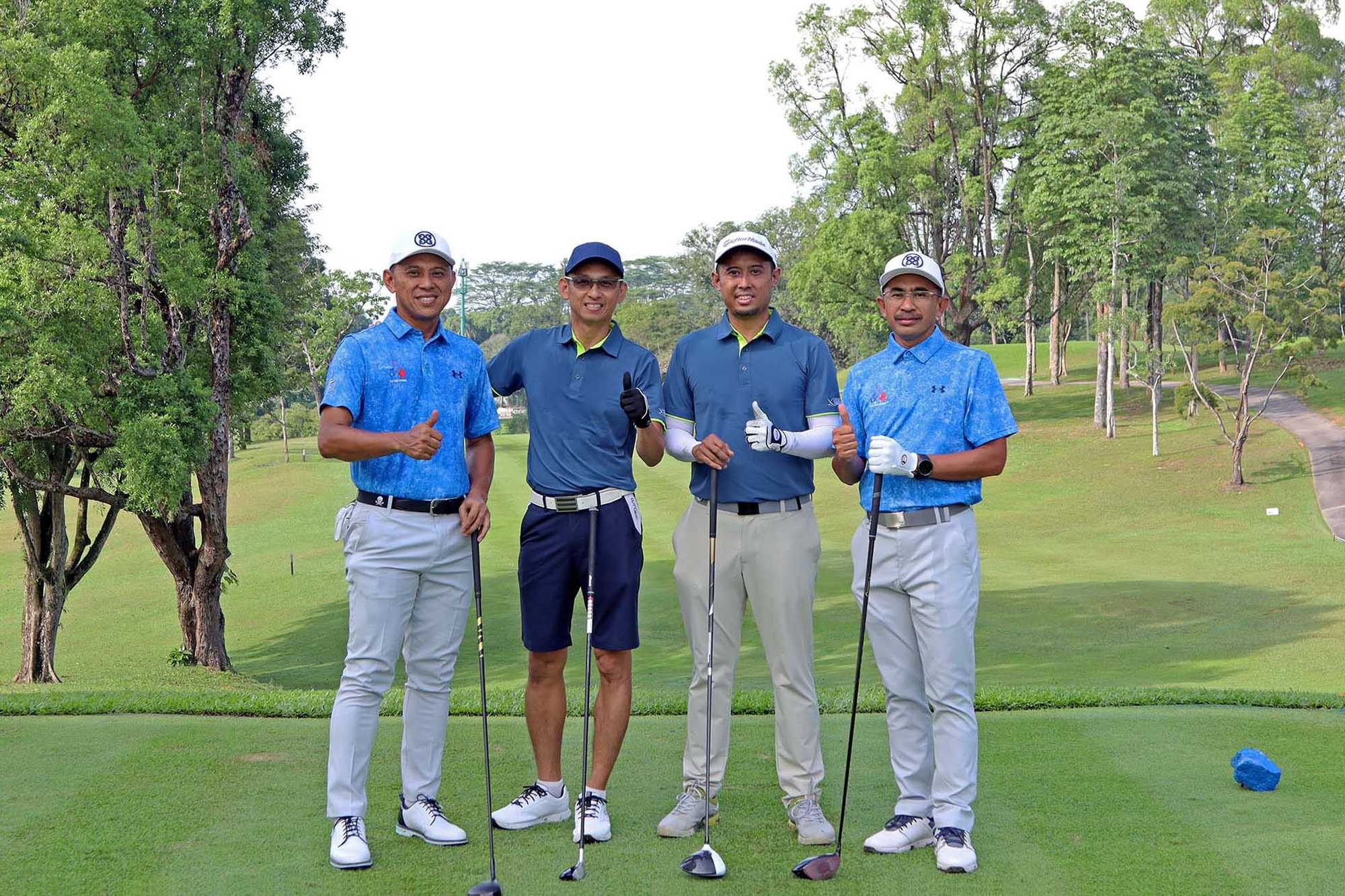 four officers wearing blue polo tees with golf sticks posing on a golf course