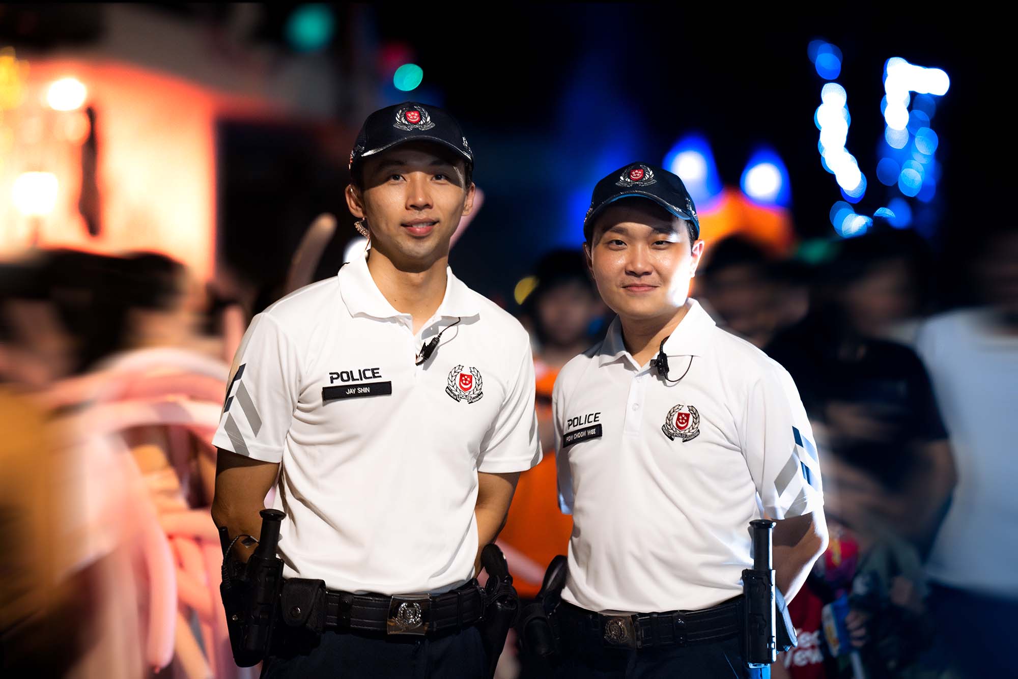 two officers in cpu uniform standing and posing for the camera amidst the halloween crowd