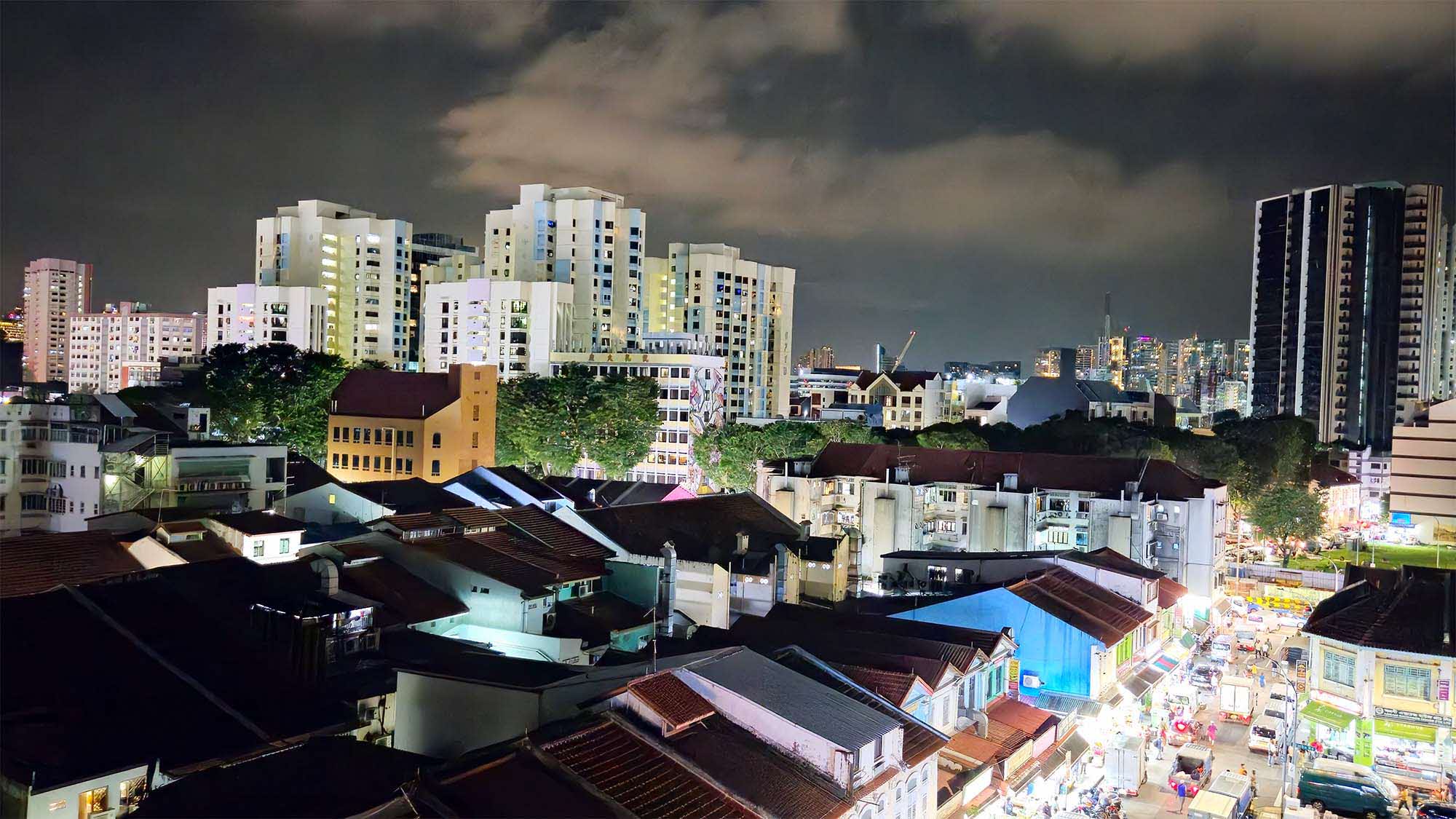 a photo overview of little india taken from a high point showing the many shophouses and street lights at night