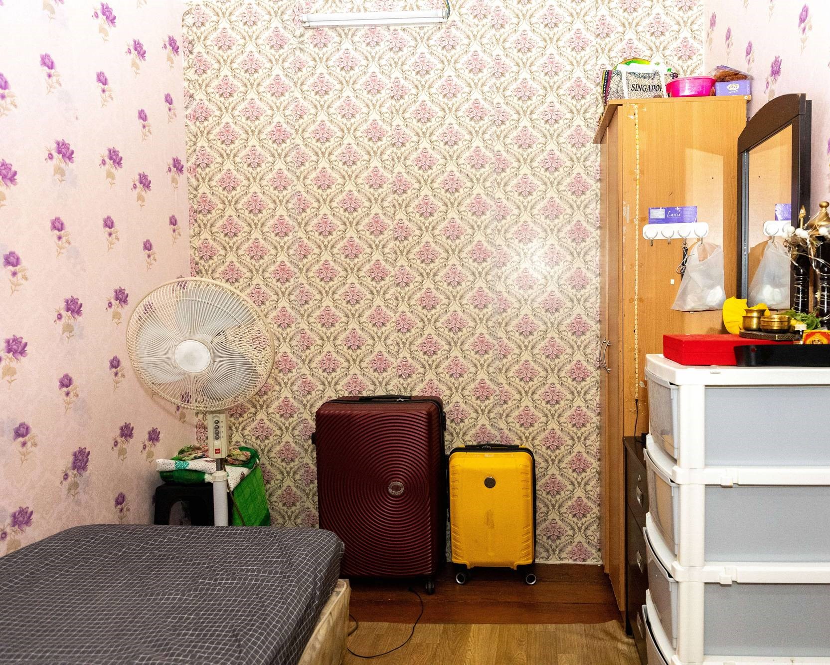 a shot of the room that is neatly arranged and decorated, with personal items seen on the dressing table and cabinet