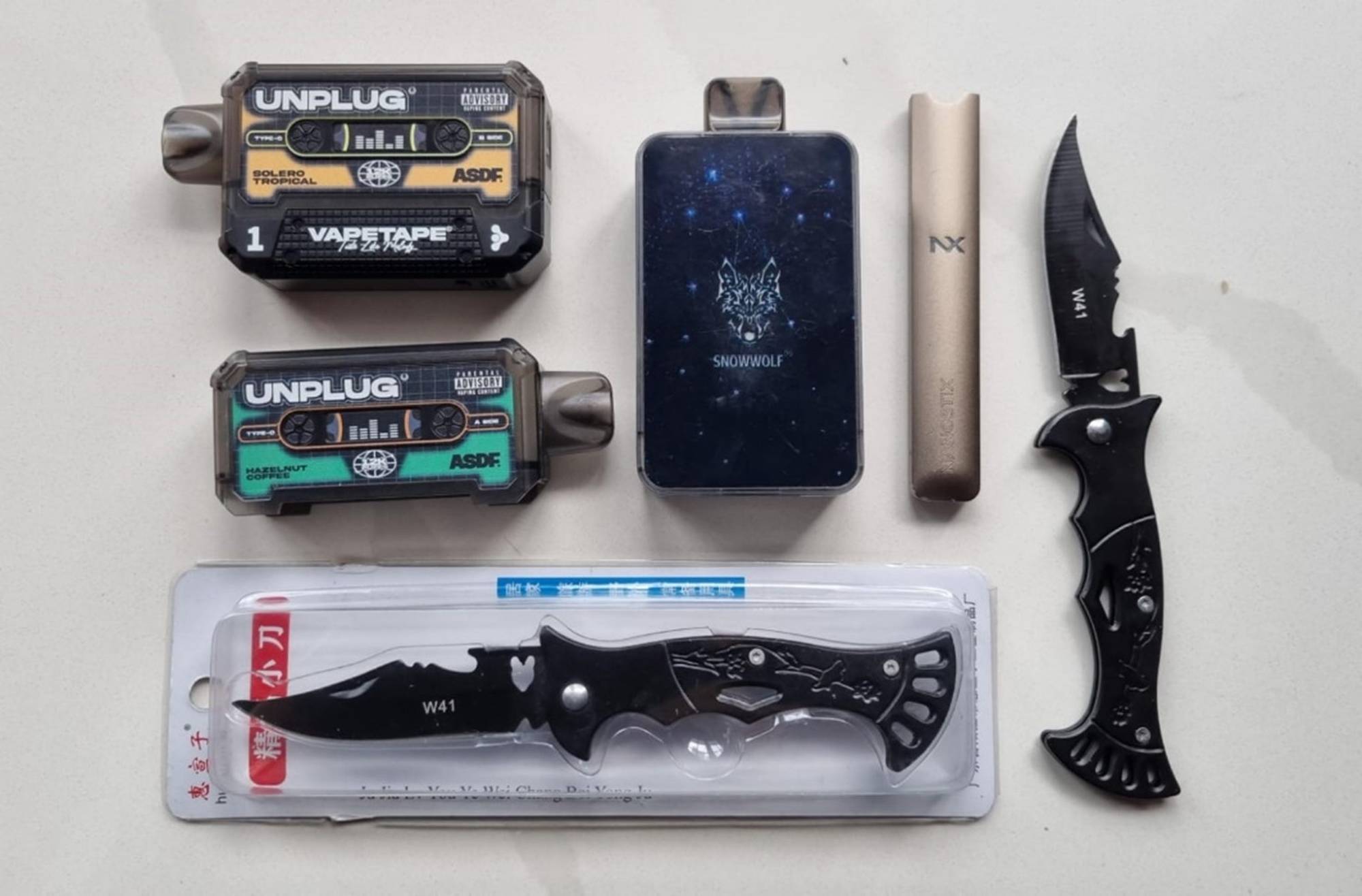 photo contains vape devices and flick knives and small knives